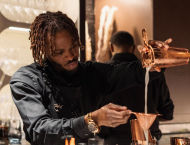 A man pours from a beaker into another cup.
