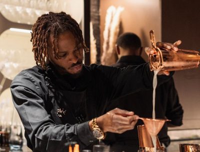 A man pours from a beaker into another cup.