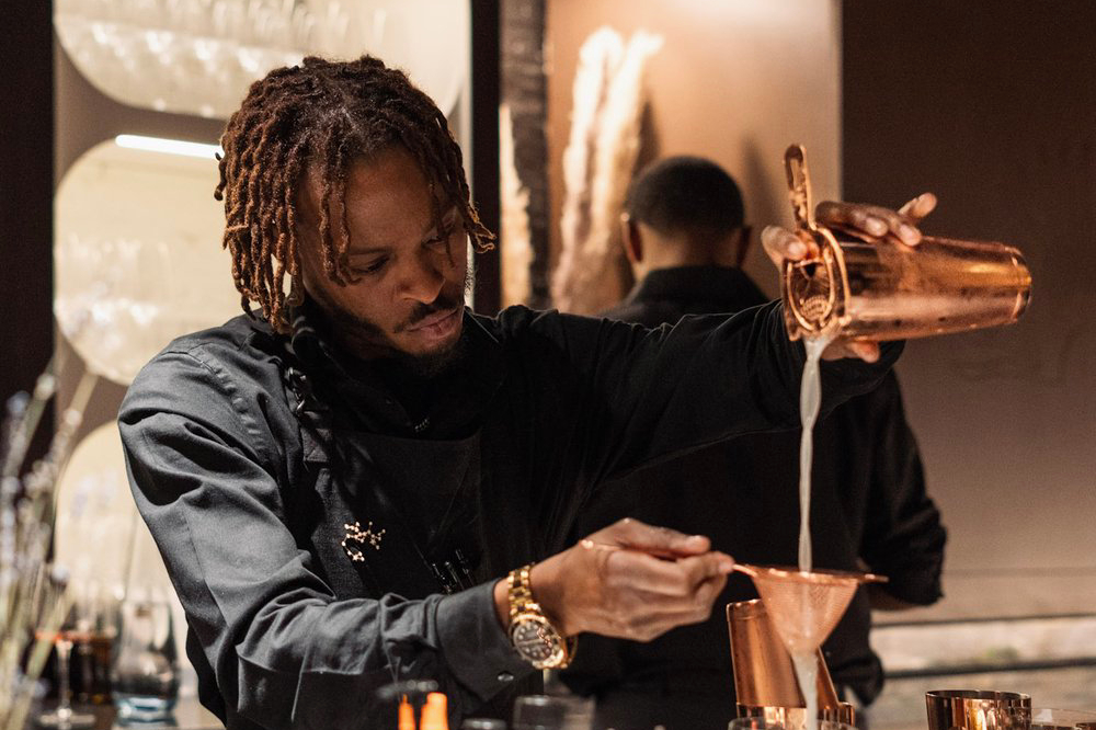 A man pours from a beaker into another cup.