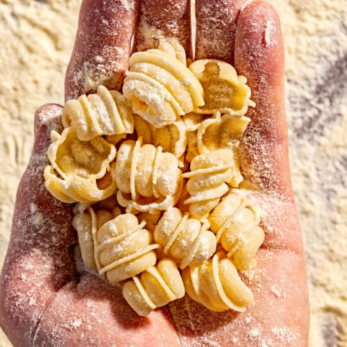 A hand holds fresh pasta.