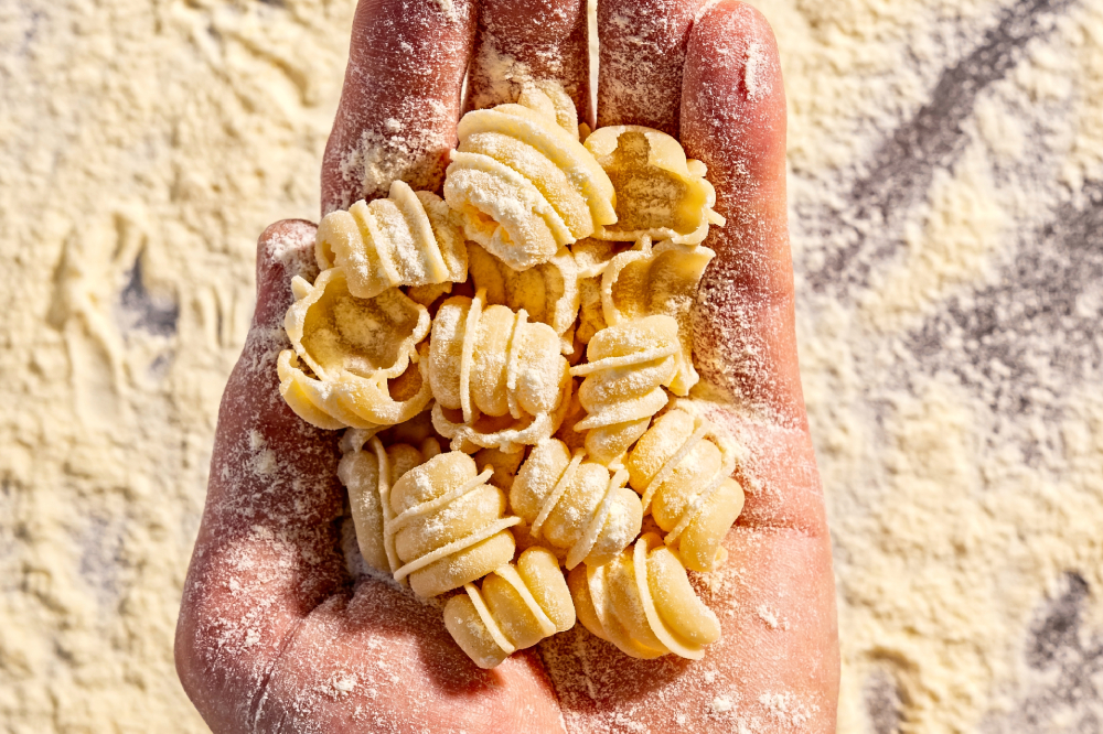 A hand holds fresh pasta.